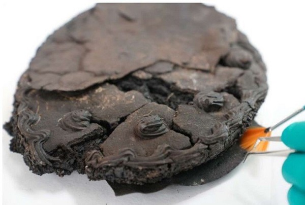 La restauradora Sylvia Morgenstern limpia con un pincel y una pinceta la tarta de nueces que fue hallada entre los restos de una vivienda destruida por el bombardeo aliado de Lübeck de 1942.